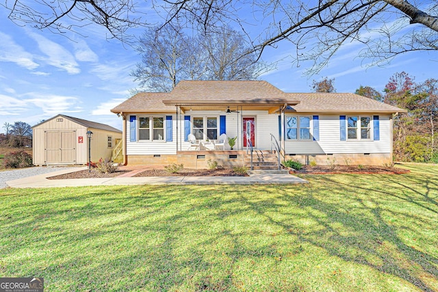 ranch-style home featuring an outbuilding, covered porch, a storage shed, a front yard, and crawl space