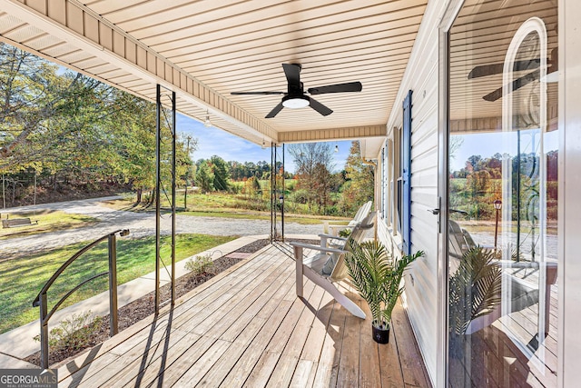 wooden terrace featuring a lawn and a ceiling fan