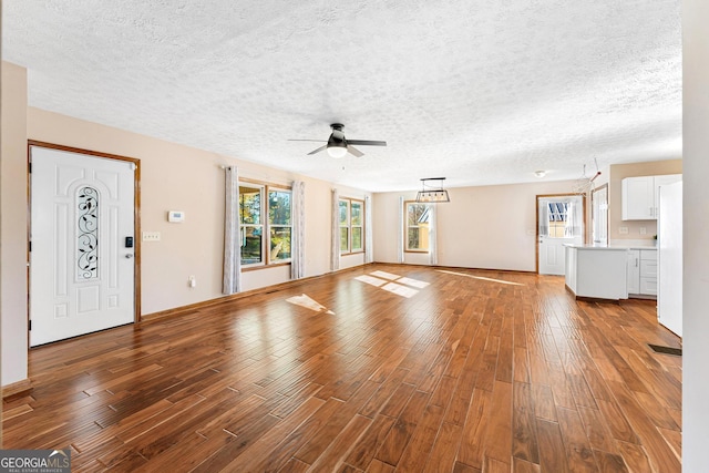 unfurnished living room with hardwood / wood-style floors, a textured ceiling, and ceiling fan