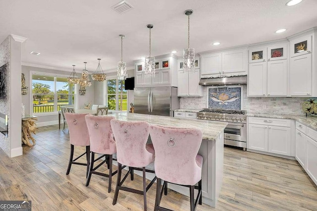 kitchen featuring white cabinets, appliances with stainless steel finishes, and extractor fan