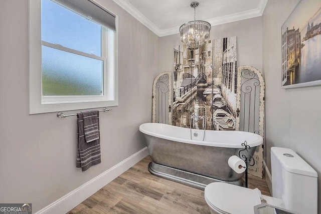 bathroom with a washtub, a chandelier, toilet, hardwood / wood-style flooring, and ornamental molding