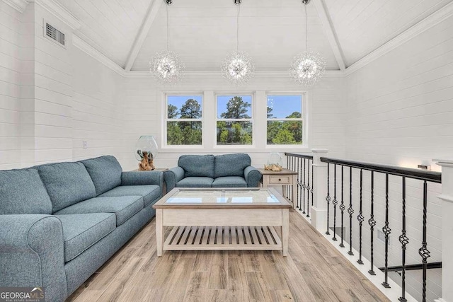 living room featuring light wood-type flooring, high vaulted ceiling, and a chandelier