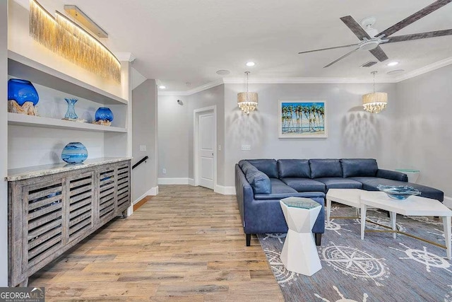 living room featuring crown molding, ceiling fan with notable chandelier, and light wood-type flooring