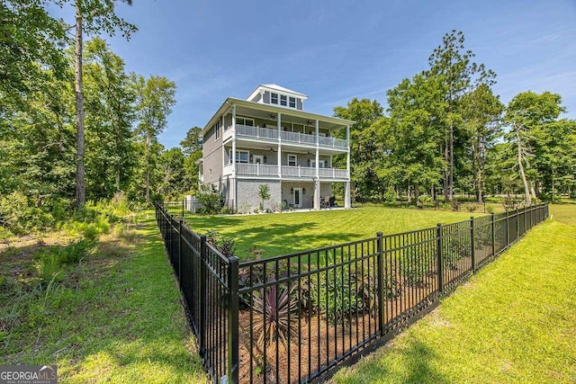 back of property featuring a balcony and a yard