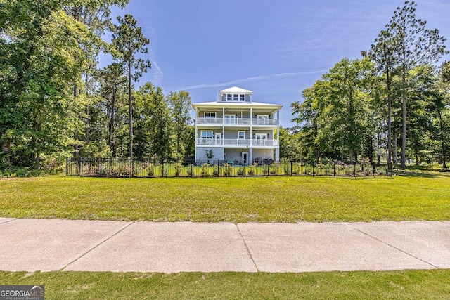 view of front of home with a front yard and a balcony