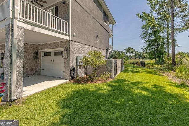 view of side of home with a lawn, ceiling fan, a garage, and a balcony