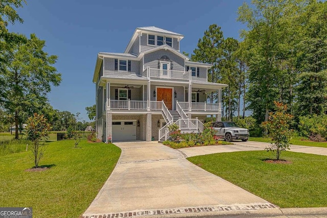 coastal home with covered porch, a garage, and a front yard