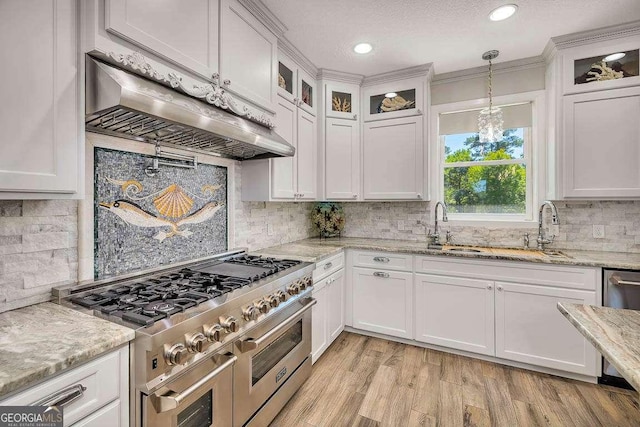 kitchen with white cabinets, stainless steel appliances, and range hood