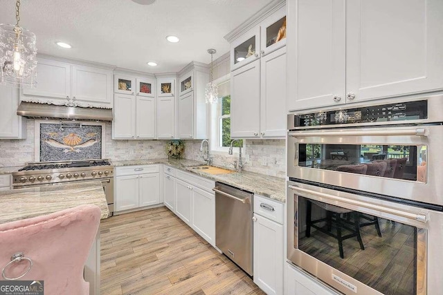 kitchen featuring light stone countertops, stainless steel appliances, and white cabinetry