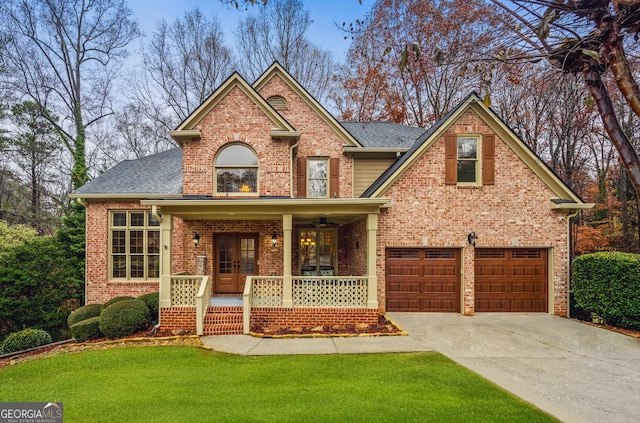 view of front of property featuring a porch, a garage, and a front lawn