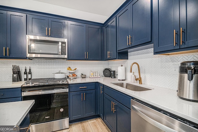 kitchen featuring blue cabinetry, appliances with stainless steel finishes, and sink