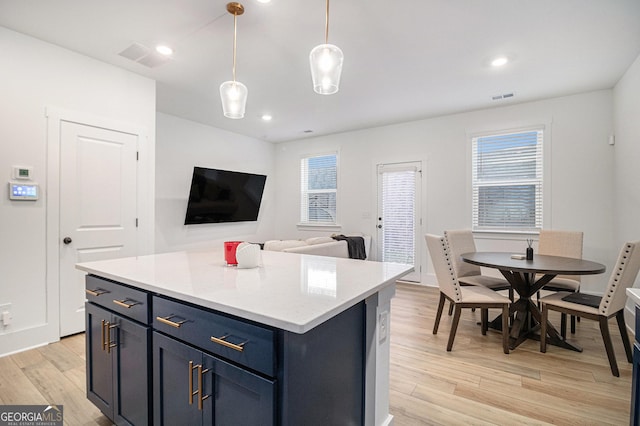 kitchen featuring light wood-type flooring, a center island, and hanging light fixtures