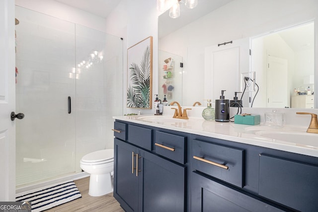 bathroom featuring vanity, hardwood / wood-style flooring, toilet, and a shower with door