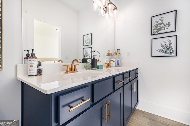 bathroom with hardwood / wood-style floors, vanity, and an inviting chandelier