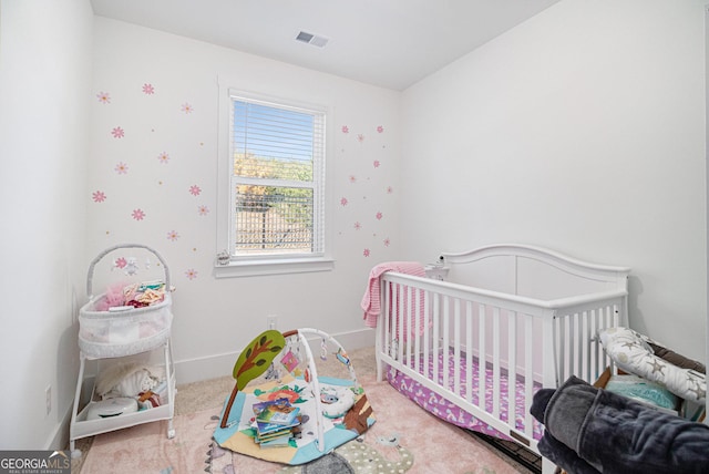 bedroom with carpet and a nursery area