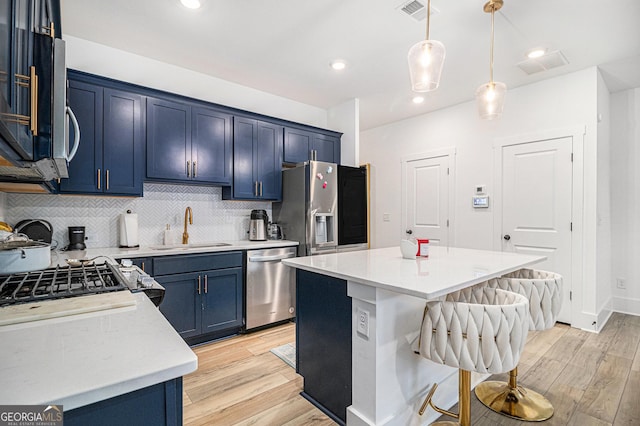 kitchen featuring a center island, sink, appliances with stainless steel finishes, and light hardwood / wood-style flooring