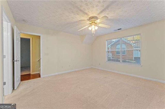 carpeted empty room with ceiling fan and a textured ceiling