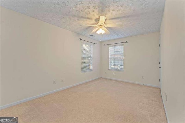 carpeted empty room featuring a textured ceiling and ceiling fan