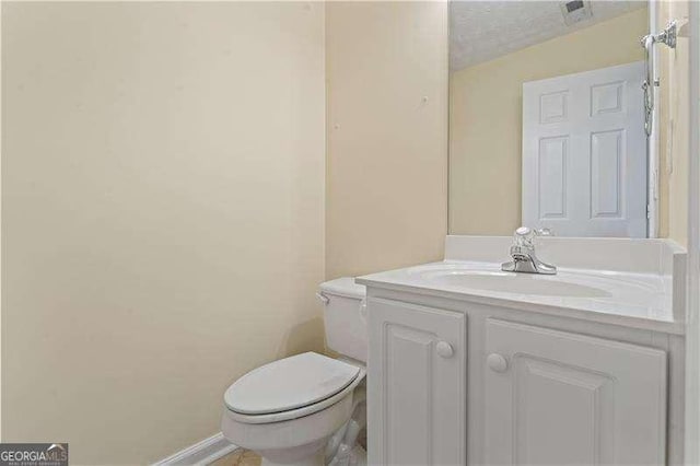 bathroom with vanity, a textured ceiling, and toilet