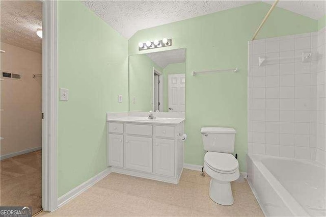 full bathroom featuring tiled shower / bath, vanity, a textured ceiling, and toilet