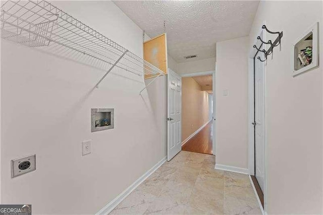 washroom featuring hookup for an electric dryer, washer hookup, and a textured ceiling