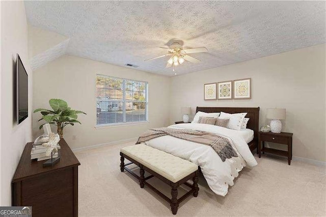 bedroom with vaulted ceiling, light carpet, ceiling fan, and a textured ceiling