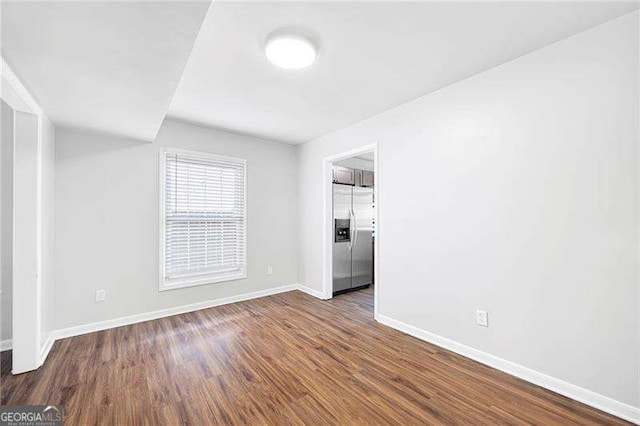 unfurnished room with dark wood-type flooring