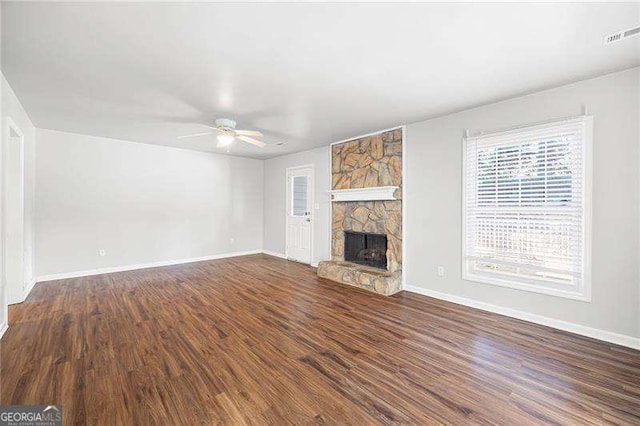 unfurnished living room featuring a fireplace, ceiling fan, and dark hardwood / wood-style flooring