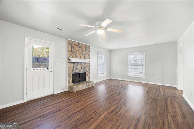 unfurnished living room featuring ceiling fan, a fireplace, and dark wood-type flooring