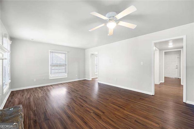 spare room featuring dark hardwood / wood-style floors, ceiling fan, and a wealth of natural light