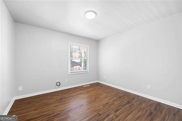 empty room with dark wood-type flooring