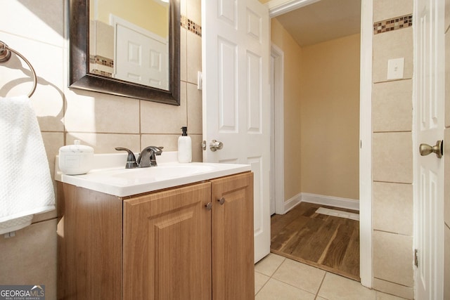 bathroom featuring backsplash, tile patterned flooring, and vanity