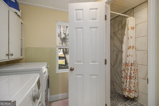 clothes washing area with cabinets and separate washer and dryer