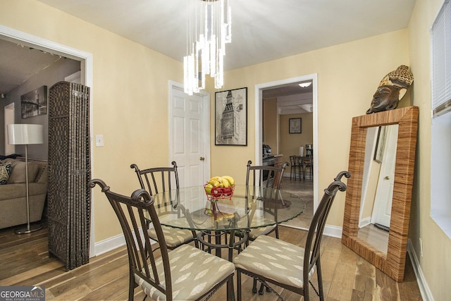 dining area with wood-type flooring and a chandelier