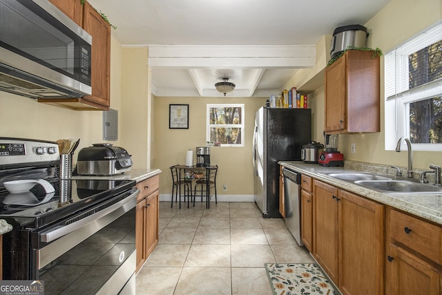 kitchen with sink, light tile patterned flooring, beamed ceiling, and appliances with stainless steel finishes