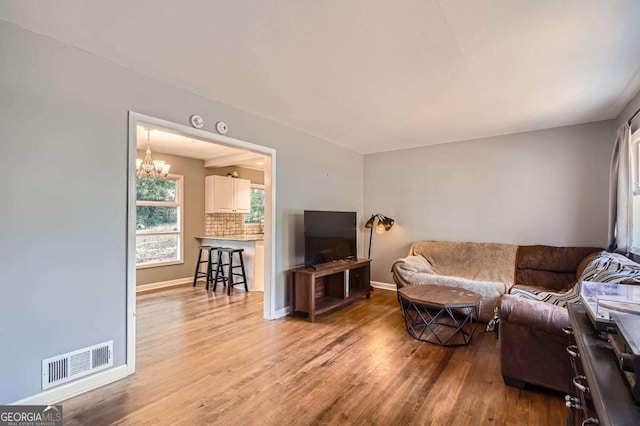 living room with wood-type flooring and a chandelier