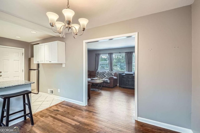 unfurnished dining area with hardwood / wood-style flooring and an inviting chandelier