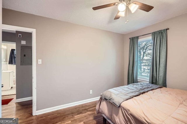 bedroom featuring ceiling fan, dark hardwood / wood-style floors, a textured ceiling, and electric panel