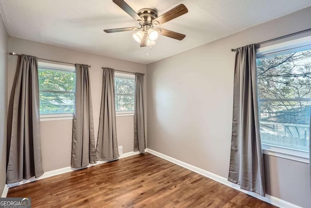 empty room featuring hardwood / wood-style floors, ceiling fan, and a textured ceiling