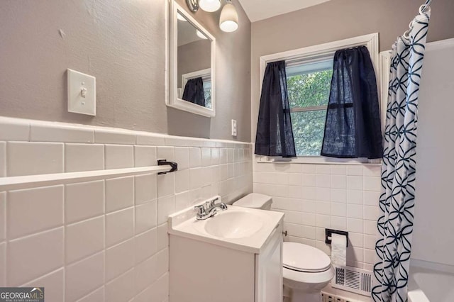 full bathroom featuring vanity, toilet, shower / bathtub combination with curtain, and tile walls