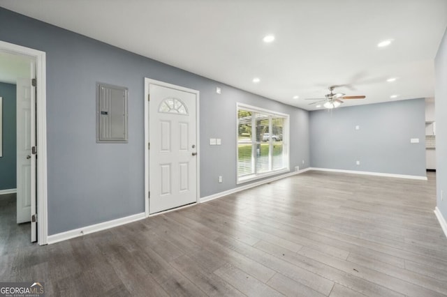 unfurnished living room featuring electric panel, ceiling fan, and light wood-type flooring