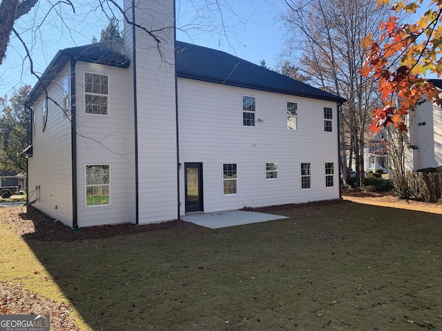 rear view of property with a yard and a patio