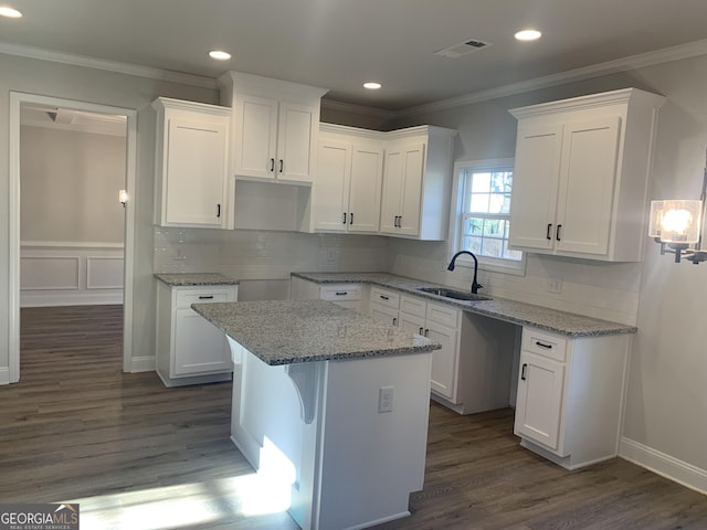 kitchen featuring white cabinetry, a kitchen island, and sink