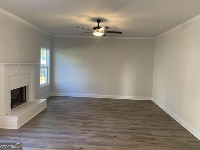 unfurnished living room featuring a fireplace, ornamental molding, dark hardwood / wood-style floors, and ceiling fan