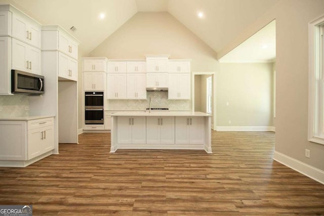 kitchen with white cabinets, decorative backsplash, and double wall oven