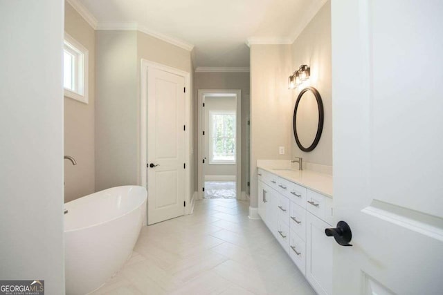 bathroom with a tub to relax in, vanity, and ornamental molding