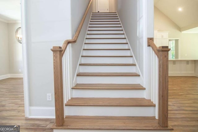 staircase featuring hardwood / wood-style flooring and ornamental molding