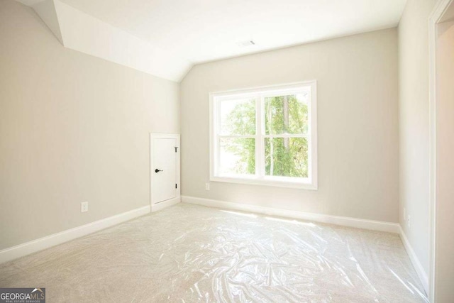 spare room with vaulted ceiling