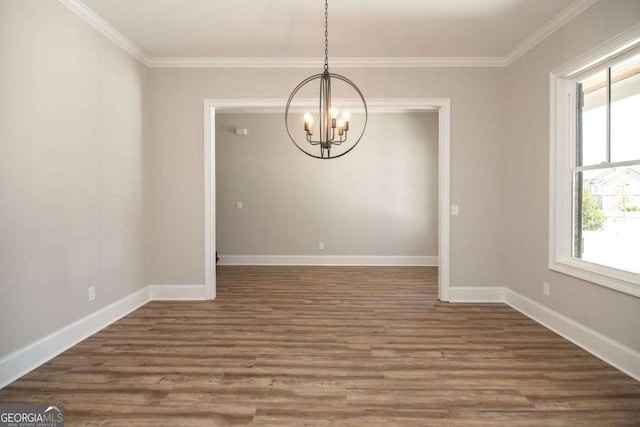 unfurnished dining area featuring a wealth of natural light, dark hardwood / wood-style flooring, crown molding, and a notable chandelier