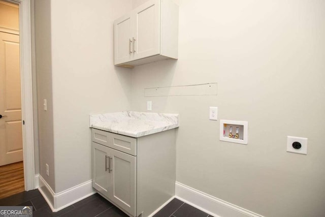 laundry room featuring washer hookup, cabinets, dark tile patterned flooring, and hookup for an electric dryer